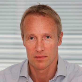 A headshot of a blonde-haired white middle-aged man