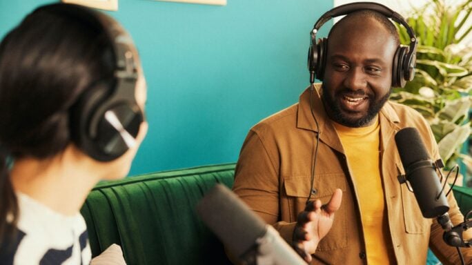 Man and woman recording a podcast in an office