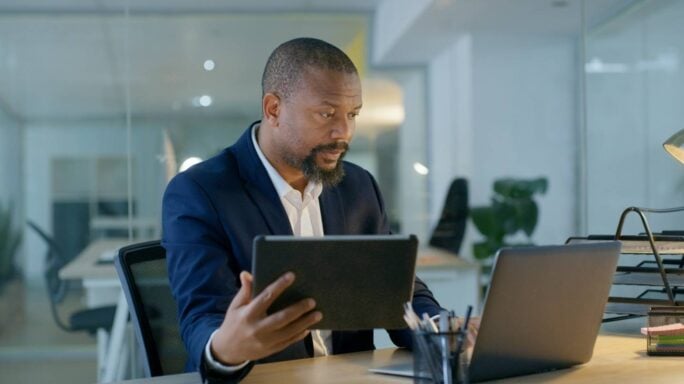 A man views his laptop in an office.