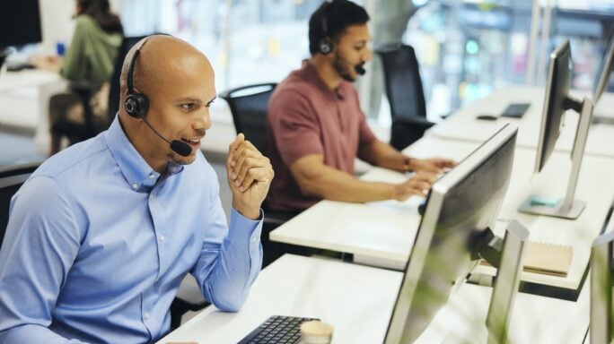 Two men working on computers in a modern office.