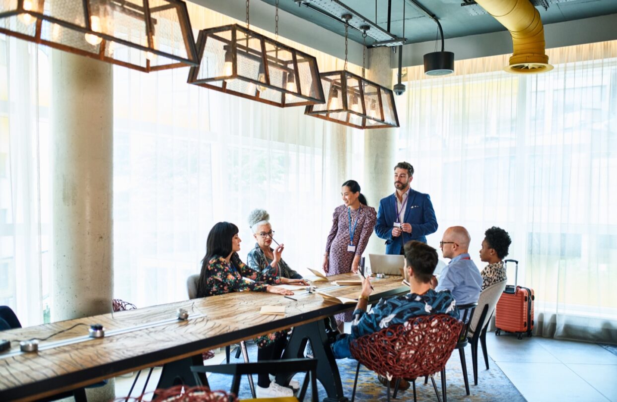 Grupo de personas reunidas alrededor de una mesa de trabajo