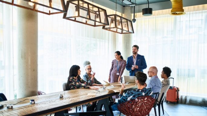 Grupo de personas reunidas alrededor de una mesa de trabajo