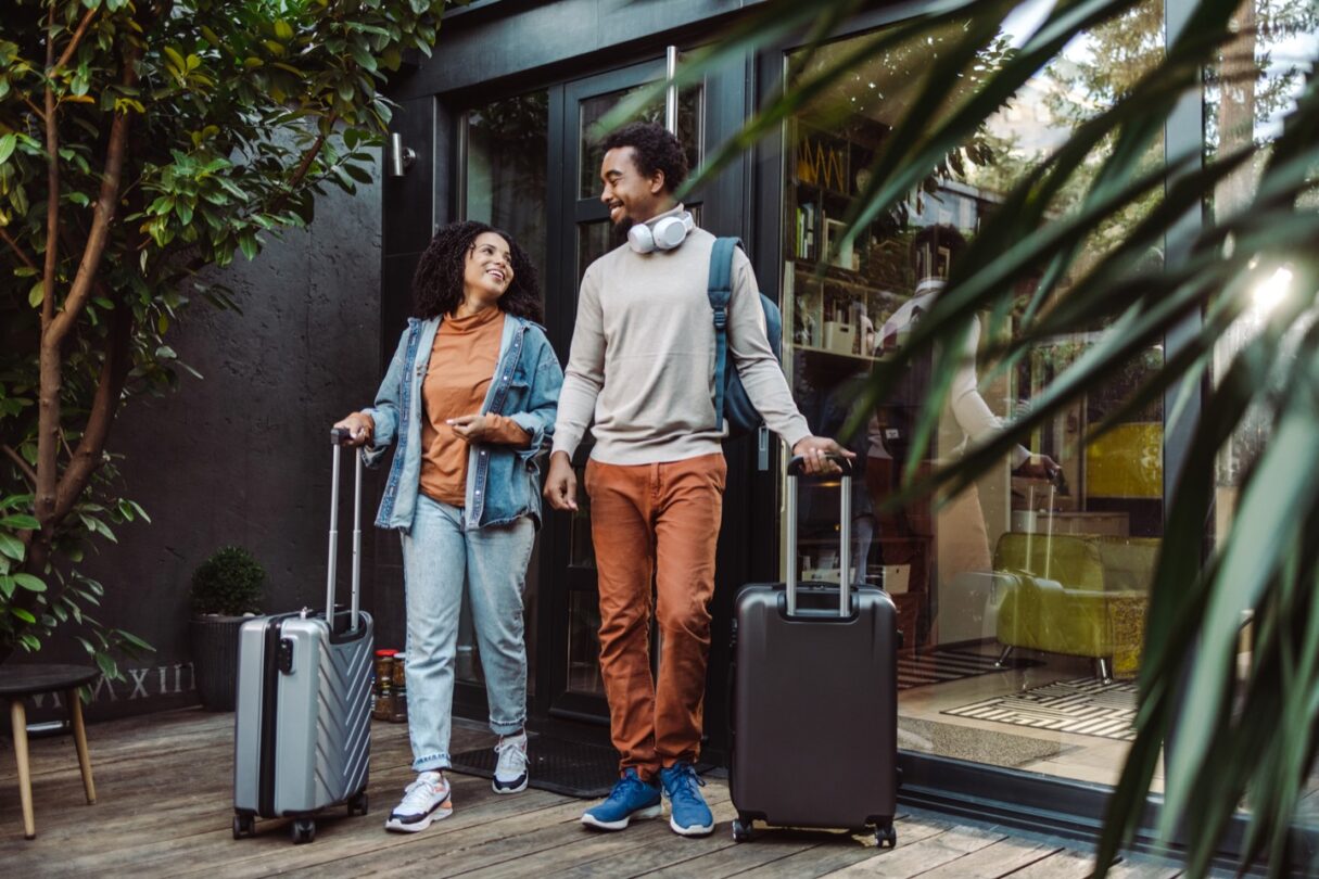 Dos personas jóvenes con maletas de viaje