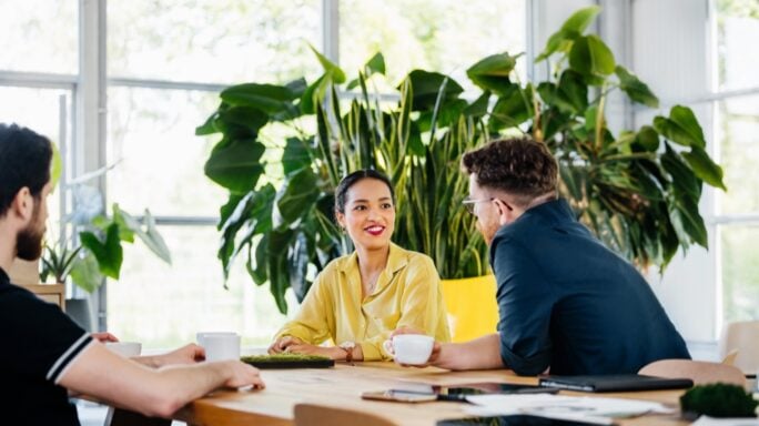 Réunion de trois collègues de bureau assis autour d'une table