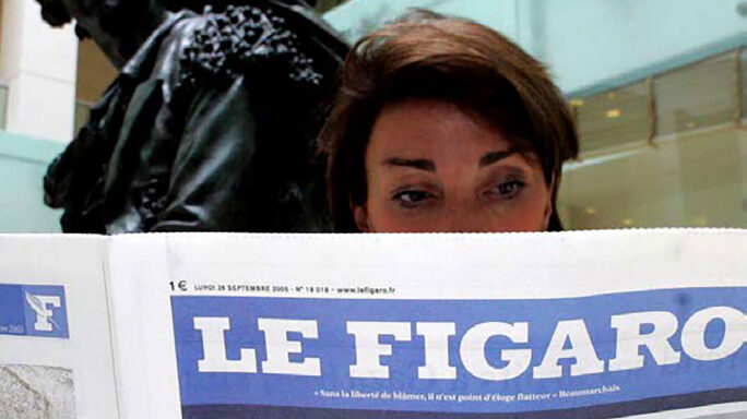 Une femme lit le journal Le Figaro